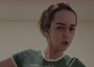 Close-up of a person wearing a green shirt with a white collar, looking at the camera indoors.