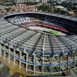 Aerial view of a large circular stadium with a green field and tiered seating.