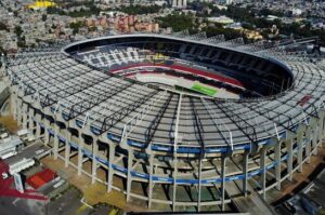 Aerial view of a large circular stadium with a green field and tiered seating.