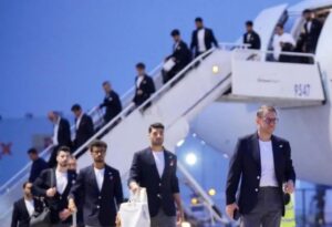 Group of men in dark blazers walking down stairs from a white airplane on the tarmac at the airport.
