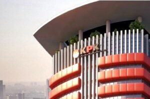 Modern office building with vertical columns and red curved accents, displaying the letters 'KPK' on the facade.