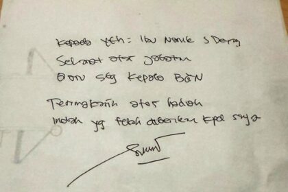 Handwritten note on white paper with a signature at the bottom; faint circular doodle on the left edge.