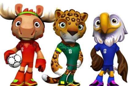 Three cartoon animal mascots in soccer uniforms: a red-moose with a ball, a green-leopard, and a blue-eagle stand together.